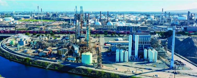 Vista aérea de una refinería y planta petroquímica junto a un río