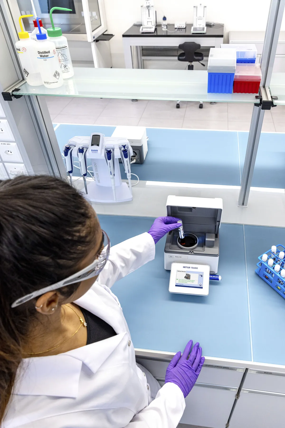 Técnica de laboratorio insertando una cubeta en el espectrofotómetro Easy UV de METTLER TOLEDO